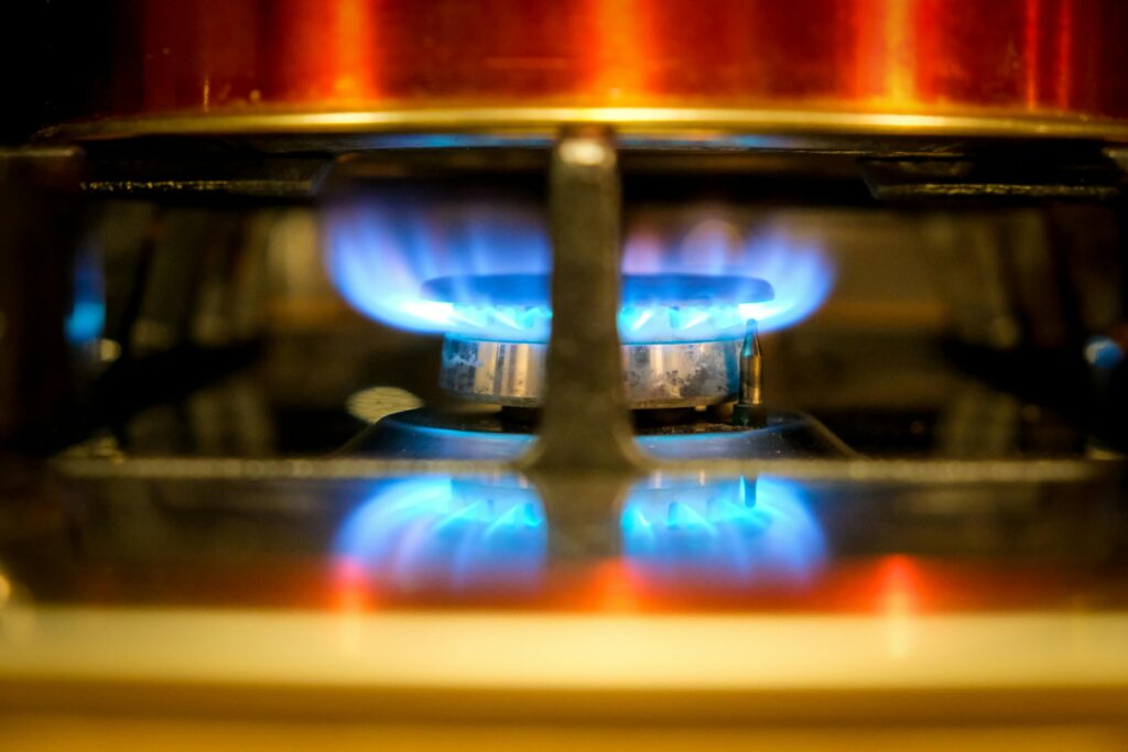 pexels-photo-3722212-3722212 Close-up of a blue flame on a gas stove burner, showcasing kitchen heat and cooking.